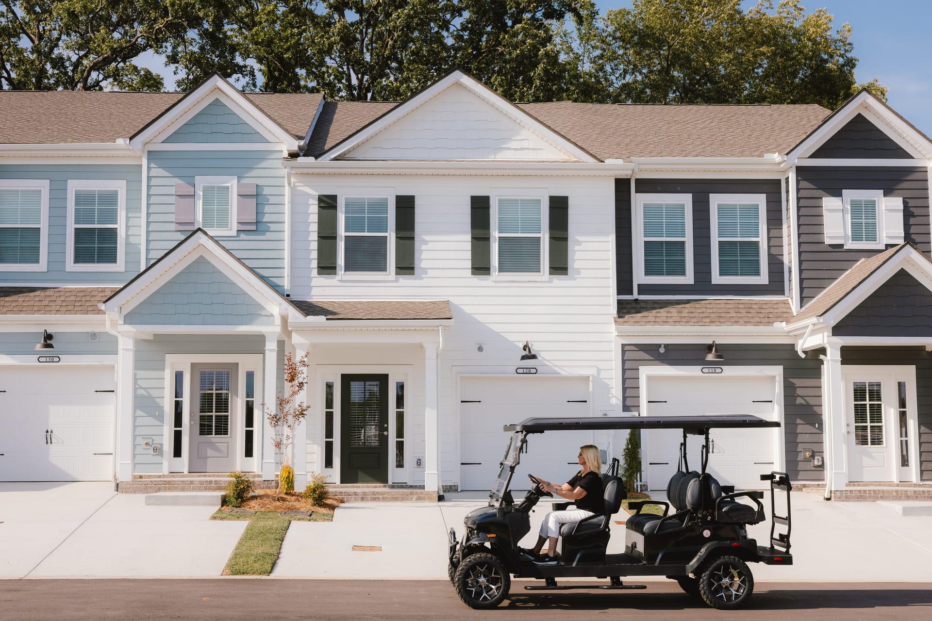 Harts Branch Townhomes, Smyrna, Tennessee: townhome fronts with covered porches and garages, a golf cart on the drive