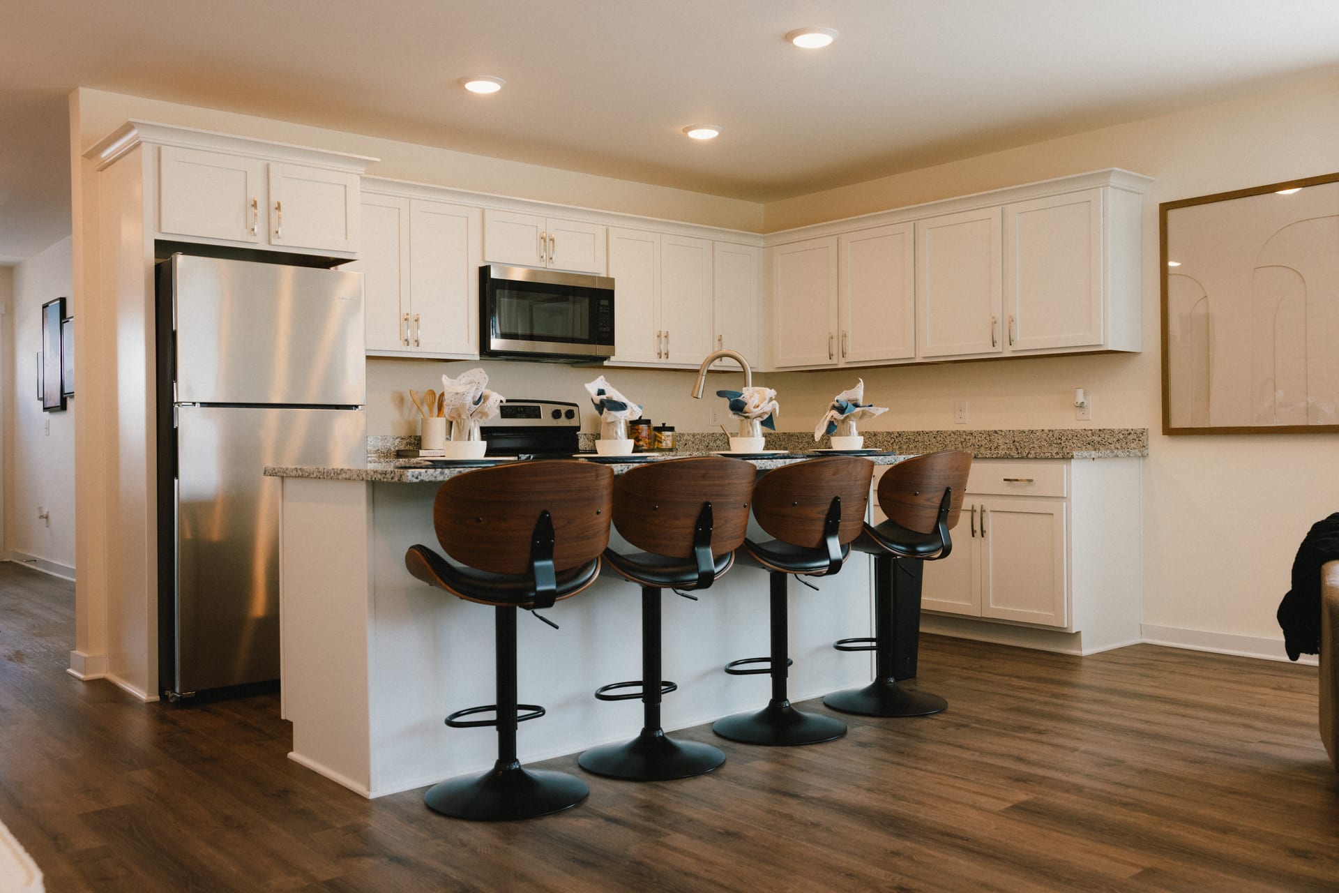 Legends Townhomes: kitchen with white cabinets and an island with bar seating