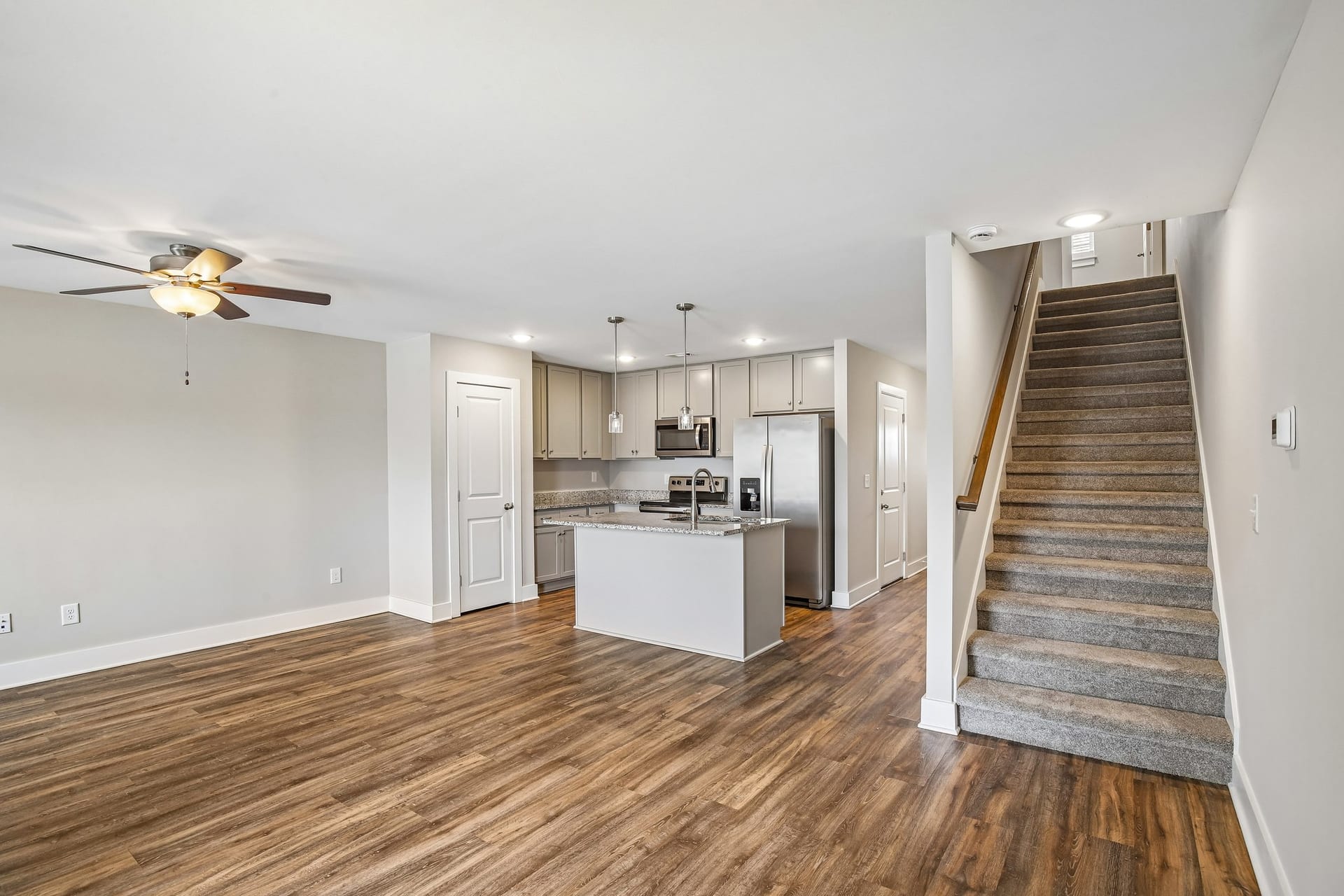 South Maple Townhomes: open living area with a kitchen island and the staircase