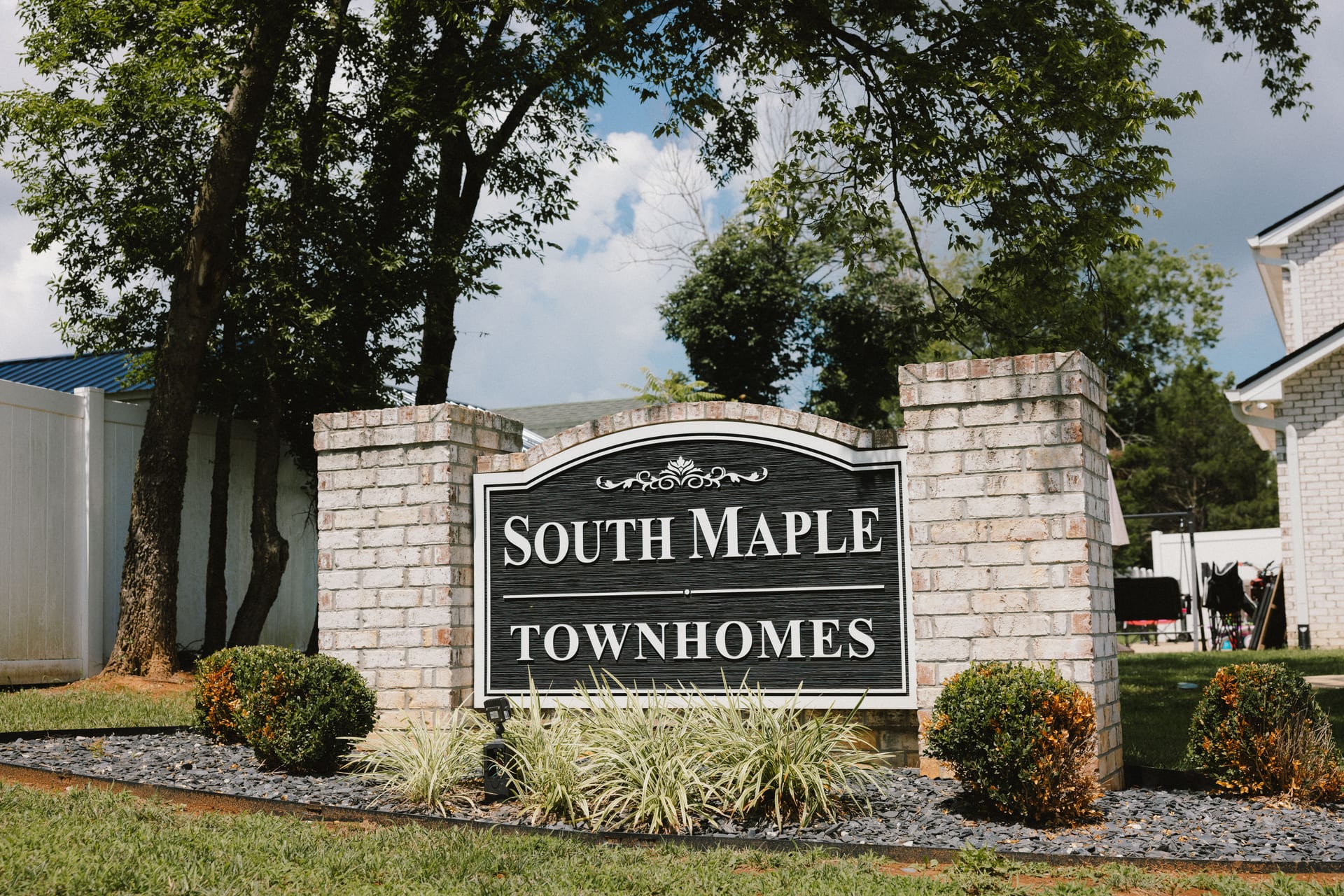 South Maple Townhomes: stone entrance sign beneath the trees