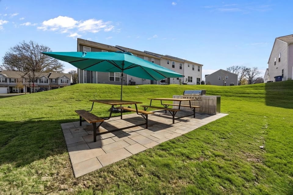 The Grove Residences: picnic tables under an umbrella on the lawn