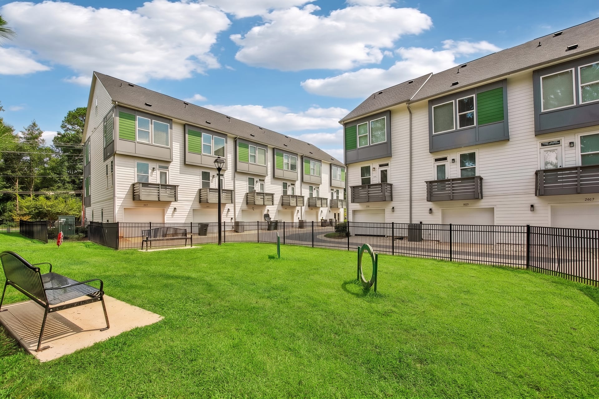 Towns at Eastland: fenced lawn with a bench behind the townhomes