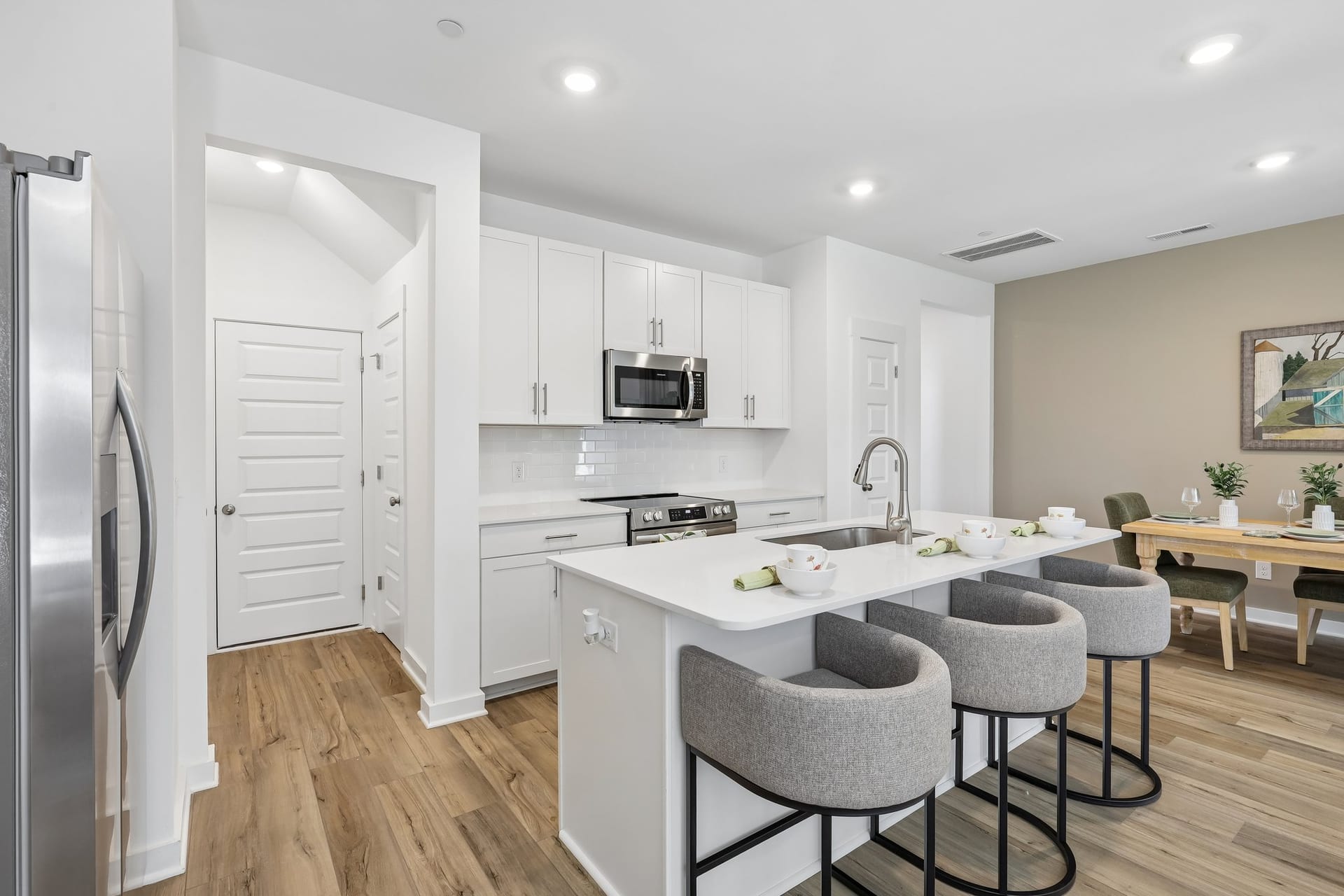 Vinewood Townhomes: kitchen with white cabinets and island seating