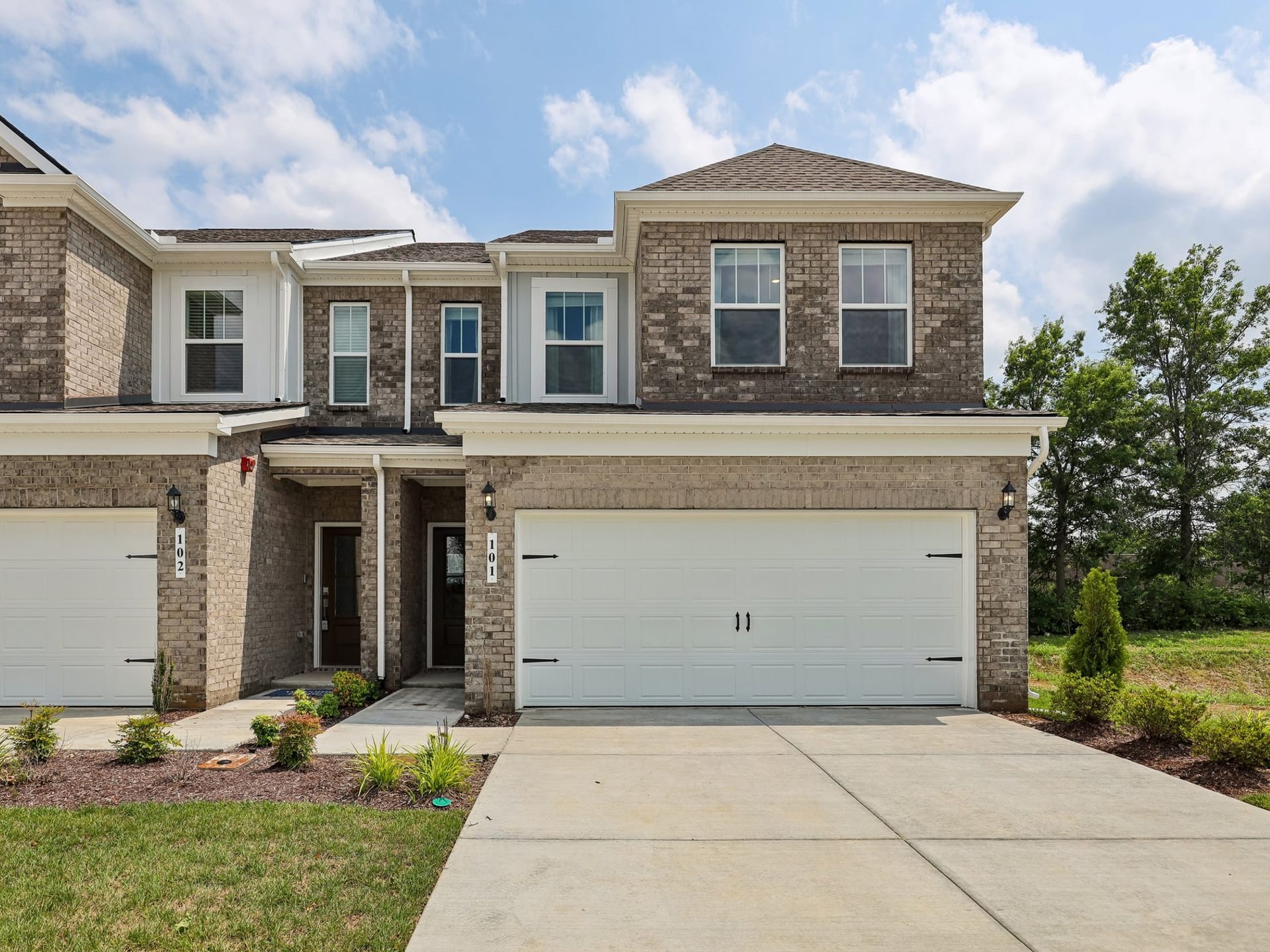 Vinewood Townhomes in Gallatin, Tennessee: brick townhome with a two-car garage and a landscaped front